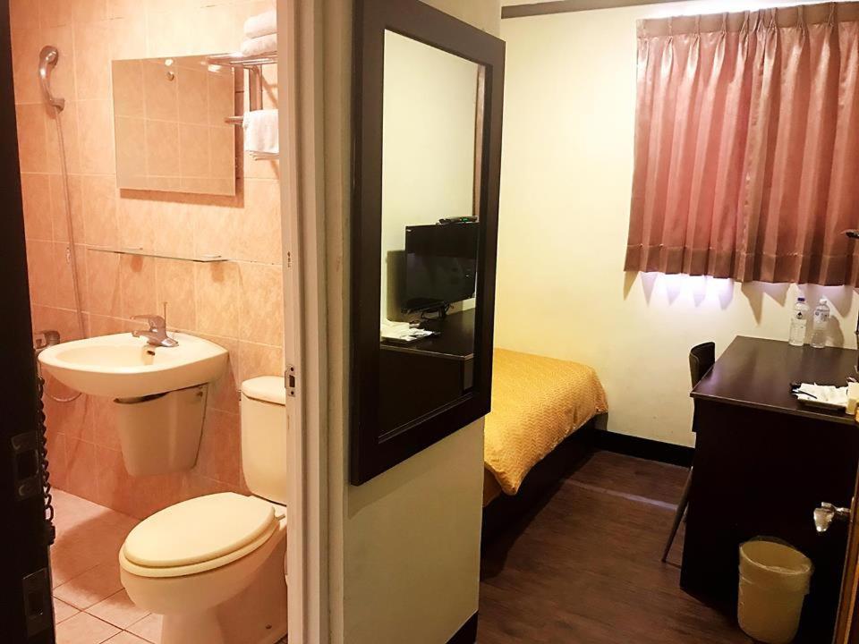 a bathroom with a toilet and a sink at Holiday Business Hotel in Taitung City