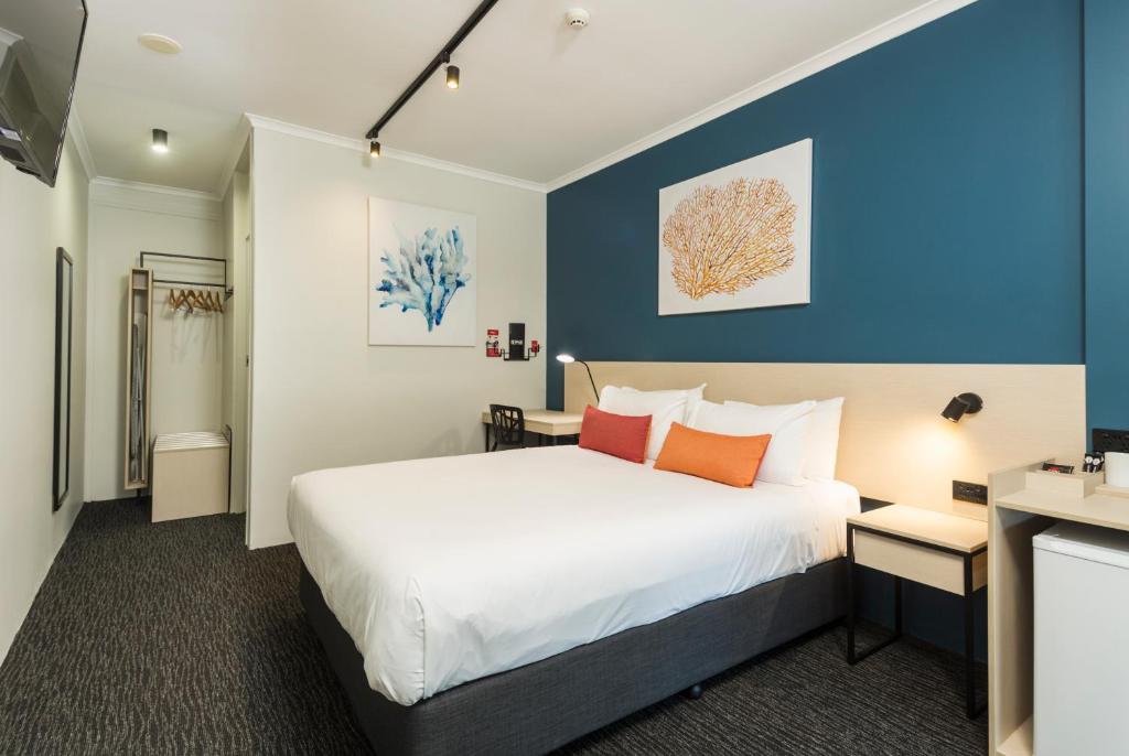1 dormitorio con cama y pared azul en Nightcap at Edge Hill Tavern, en Cairns