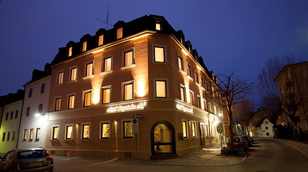 un grande edificio è illuminato di notte di Bayerischer Hof a Ingolstadt