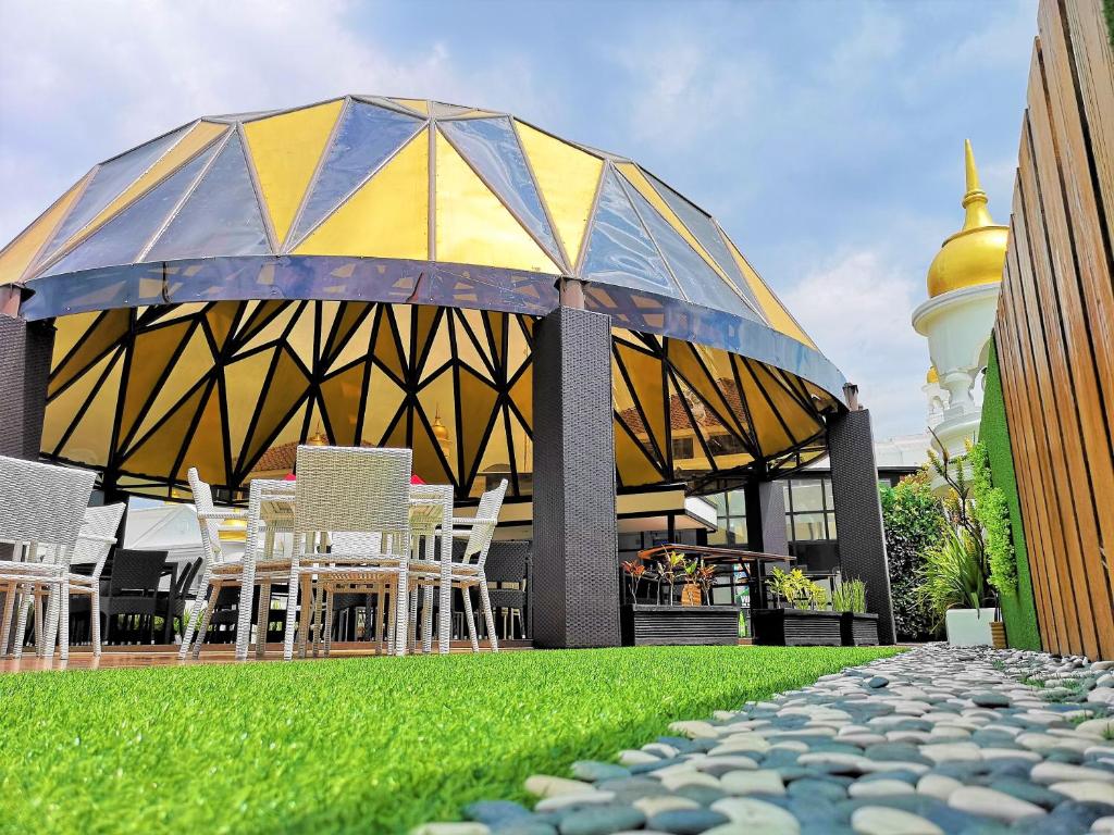 a table and chairs under an umbrella on a building at Tara Hotel Yogyakarta in Yogyakarta