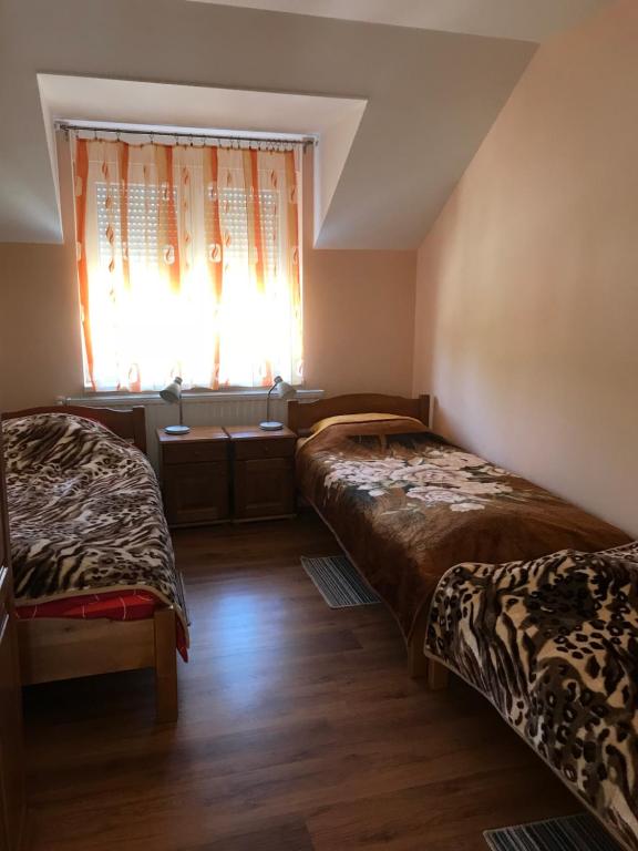two beds in a room with a window at Vila de lux in Bela Crkva