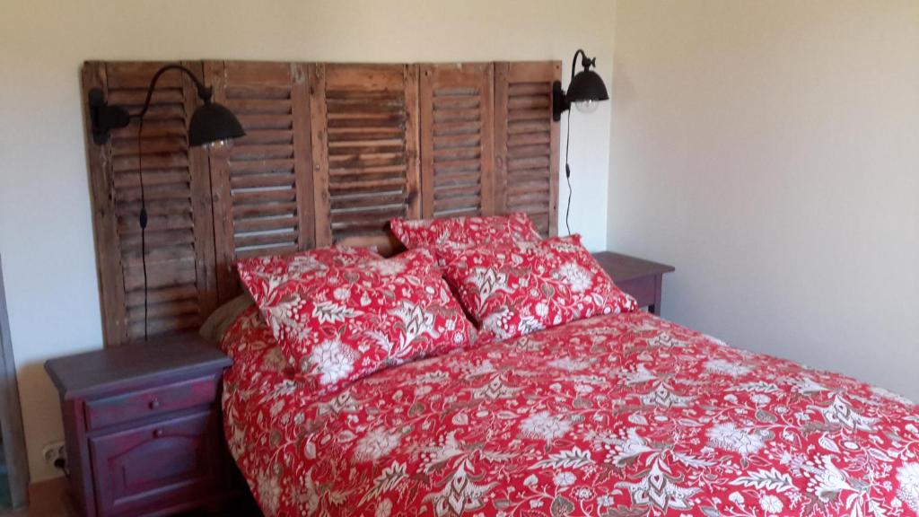 Cama roja con almohadas rojas y cabecero de madera en Clos St Jean Baptiste, en Tourves