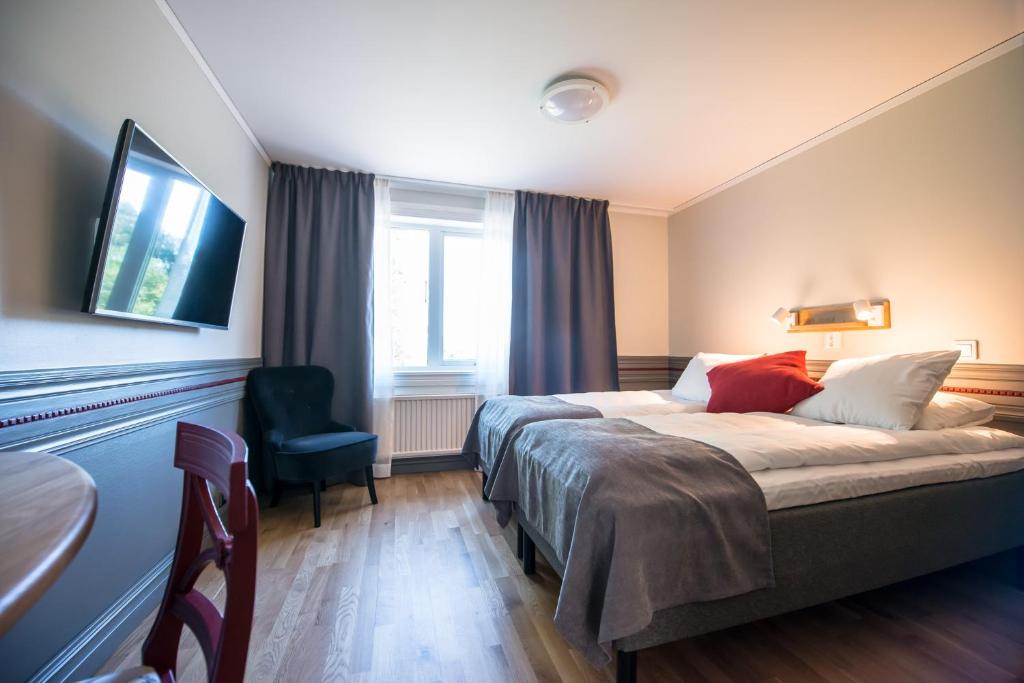 Habitación de hotel con cama y silla en Gylle Hotell & Restaurang Brödernas en Borlänge