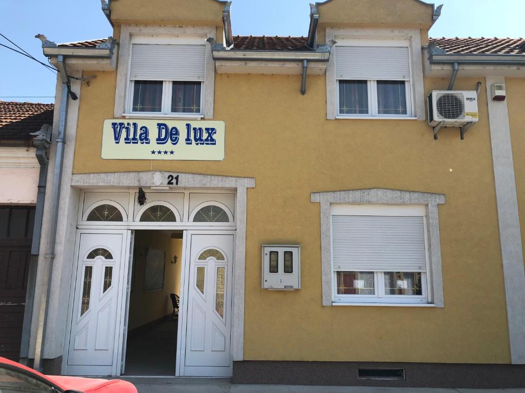 a yellow building with a sign that reads vita de lux at Vila de lux in Bela Crkva