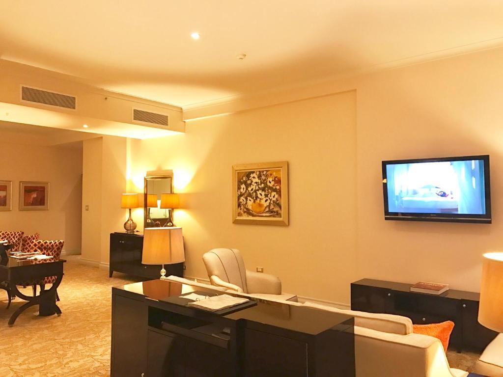 a living room with a flat screen tv on the wall at Taj HotelApart, Taj Hotel Cape Town in Cape Town