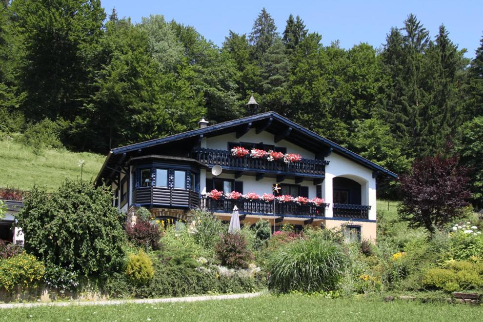 uma casa com uma varanda com flores em Gästehaus Marlies Keutschach am See em Keutschach am See