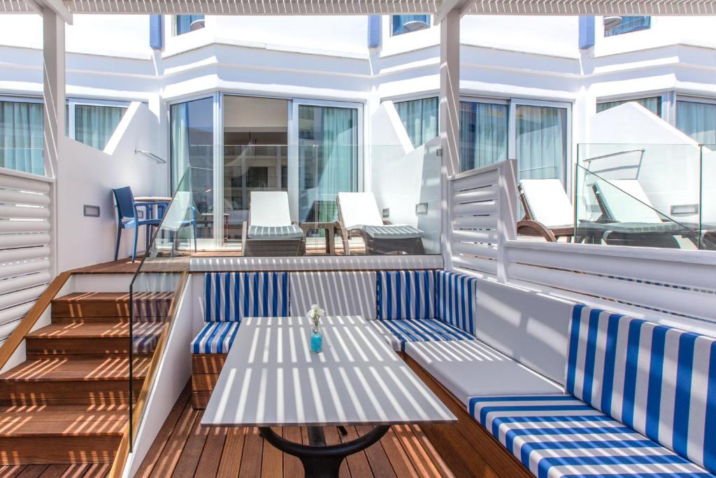 a deck with a bench and chairs on a cruise ship at Lordos Beach Hotel & Spa in Larnaca