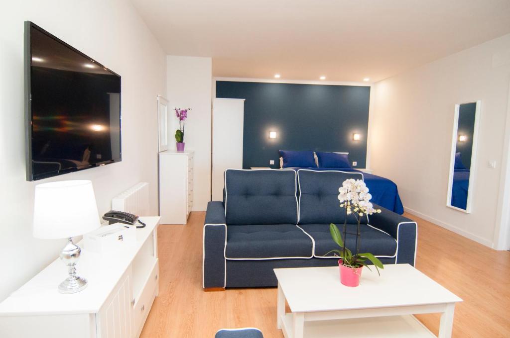 a living room with a blue couch and a bed at Los Rodeos Luxury Vivienda Vacacional in La Laguna