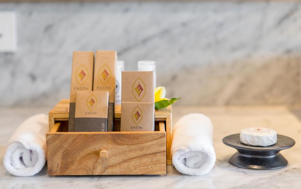 a wooden box with toilet paper and towels on a table at Eastin Ashta Resort Canggu in Canggu