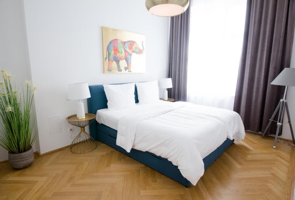 een slaapkamer met een groot bed met witte lakens bij Studio Apartments Urania - Mai's Apartments by Arbio in Wenen