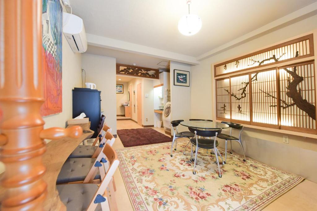 ein Wohnzimmer mit einem Tisch und Stühlen in der Unterkunft Yoyogi House in Tokio