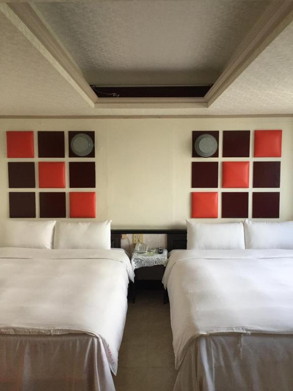 duas camas num quarto com quadrados vermelhos e castanhos em King Lo Tung Hotel em Luodong
