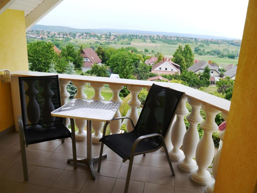 einen Balkon mit einem Tisch und Stühlen sowie Aussicht in der Unterkunft Hévíz Villa-Erika Apartman in Alsópáhok