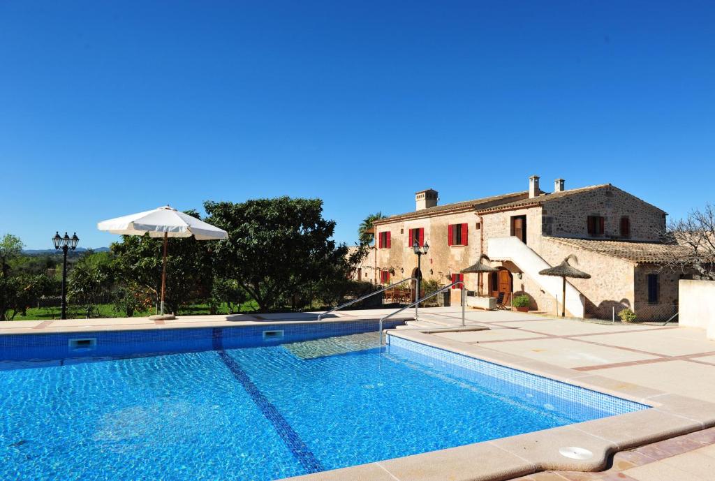 a large swimming pool in front of a house at Finca Ses Cases Noves in Sant Llorenç des Cardassar