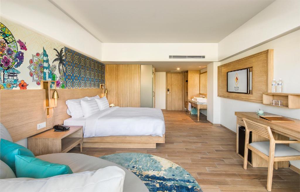a hotel room with a bed and a desk at Eastin Ashta Resort Canggu in Canggu
