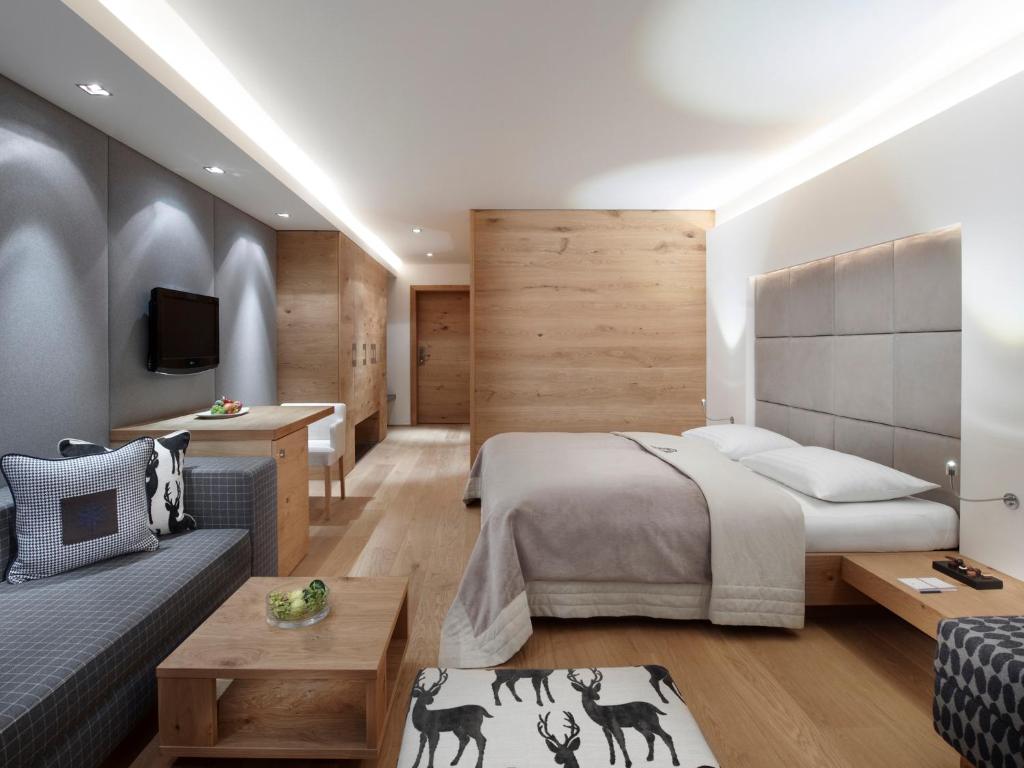 a bedroom with a bed and a living room at Schwarzer Adler Kitzbühel - Adults Only in Kitzbühel