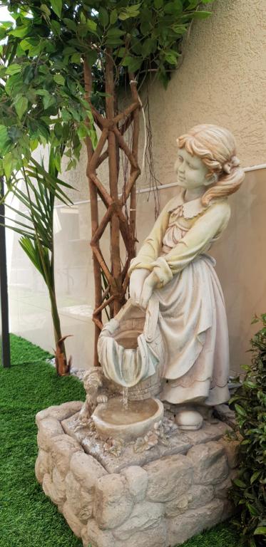a statue of a woman sitting next to a fountain at Shahal Apartments in Beer Sheva