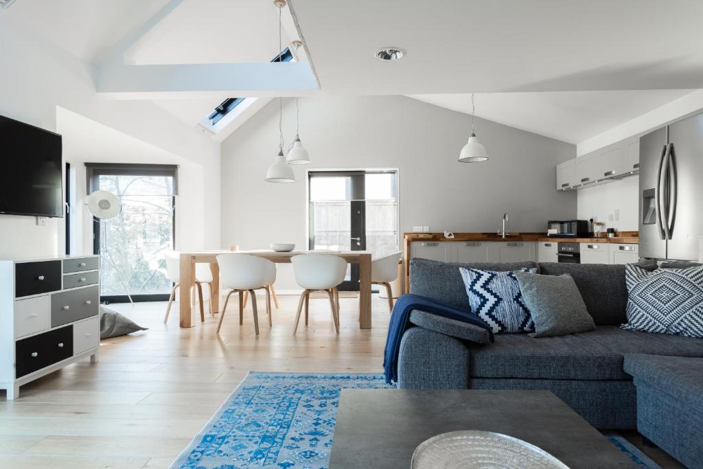 The Cliffside Loft - Distinctly Modern 3 BDR Riverside Home في باث: غرفة معيشة مع أريكة وطاولة