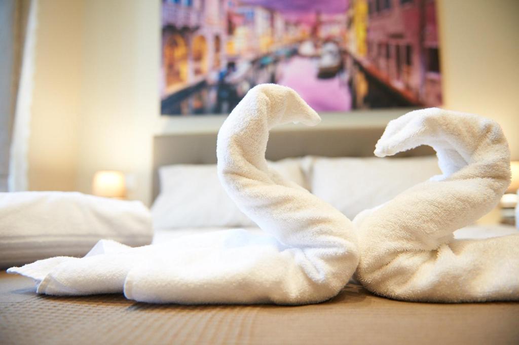 得利雅斯特的住宿－Miramare Luxury Suites，两条毛巾,形状像天鹅,铺在地板上