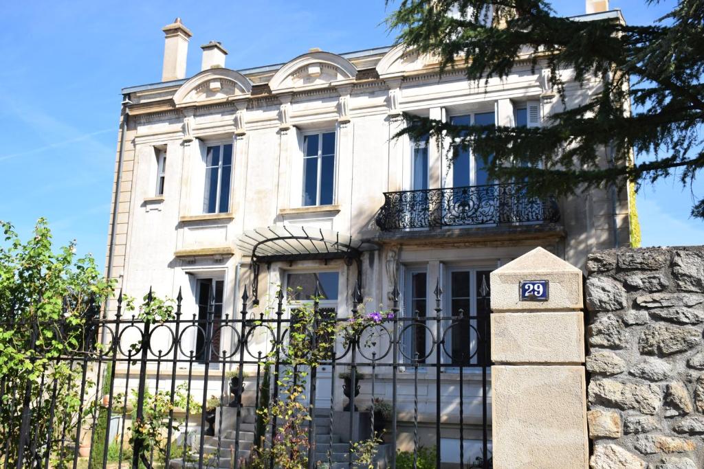 una gran casa blanca con una puerta y una valla en CLOCHI-CLOCHA en Montbrison