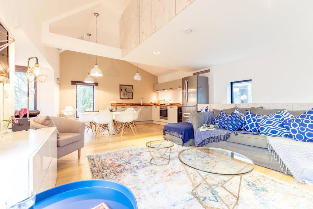 a living room with a couch and a table at The Cliffside Chalet - Modern 3BDR Riverside Home in Bath