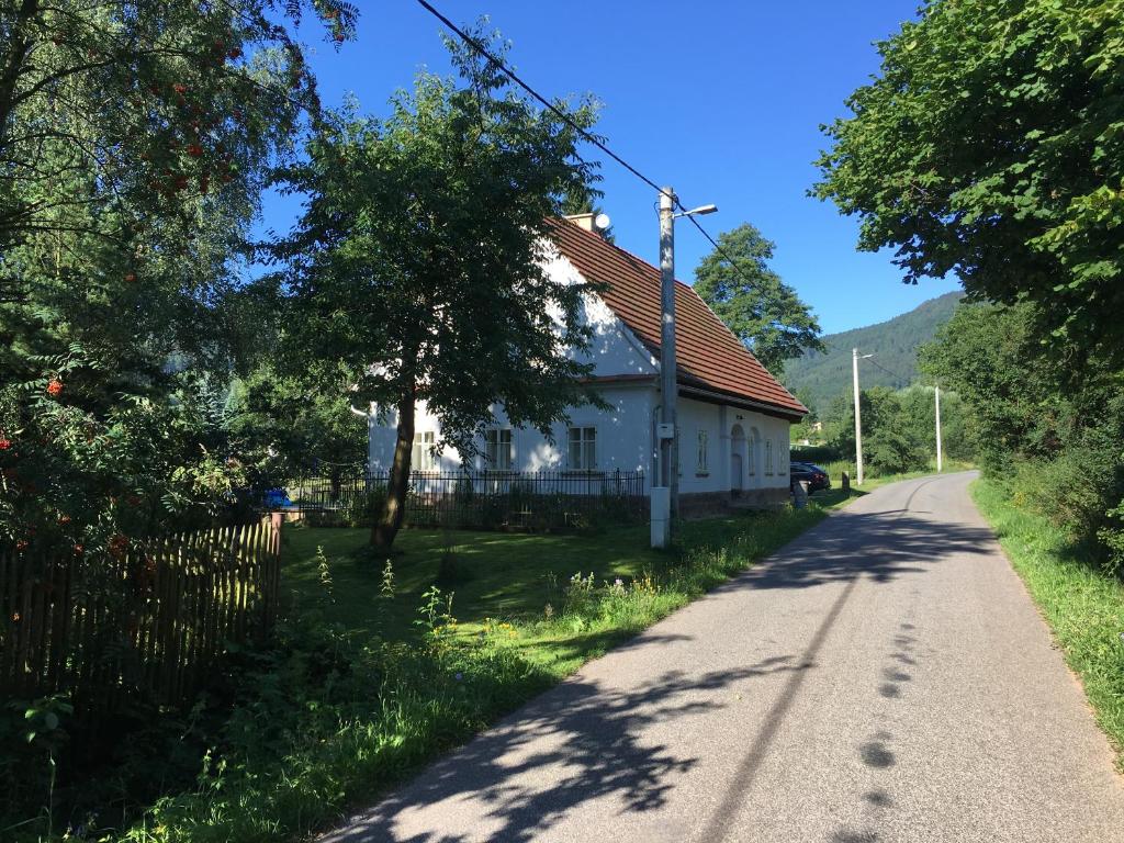 ein weißes Haus am Straßenrand in der Unterkunft Chalupa u Broumovských stěn in Božanov