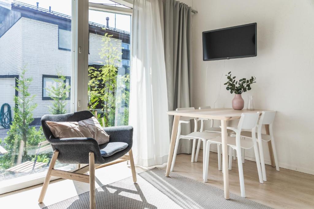 Una sala de estar con una mesa y sillas y una ventana. en Spot Apartments Martinlaakso, en Vantaa