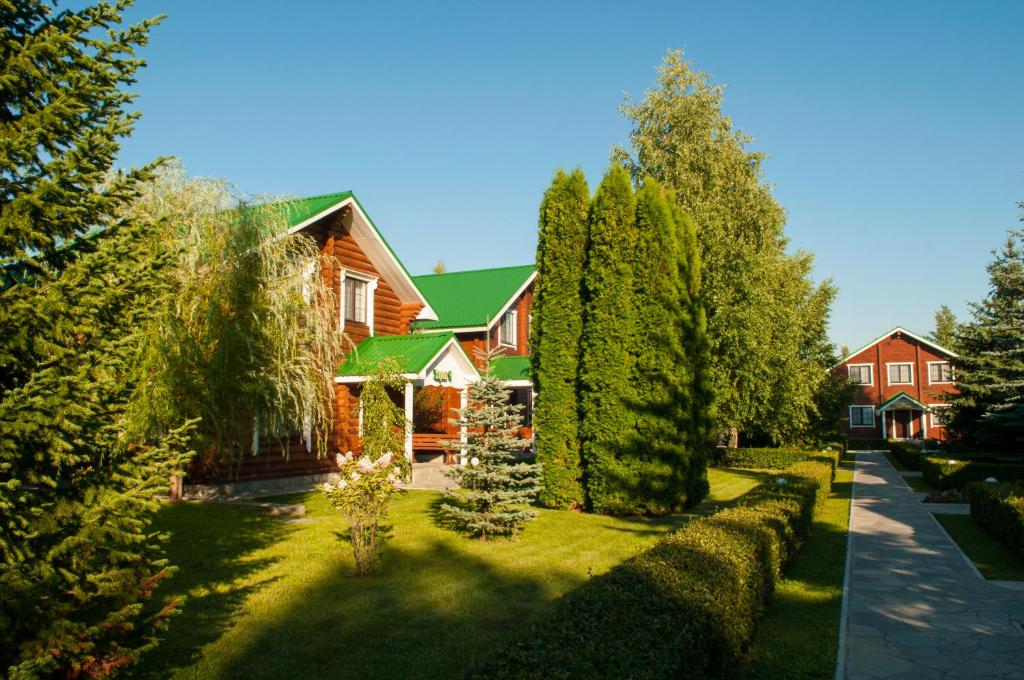 una casa con un patio con árboles y arbustos en Russkaya Okhota Hotel, en Kurumoch