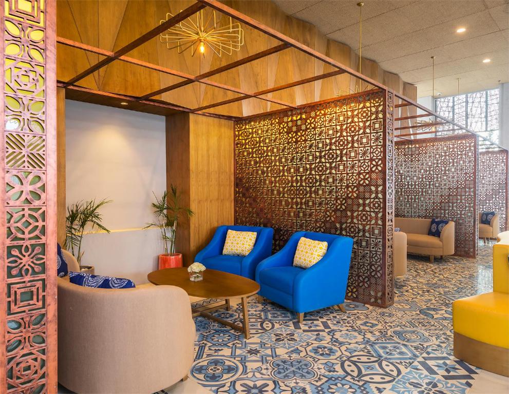 a lobby with blue chairs and a table at Eastin Ashta Resort Canggu in Canggu