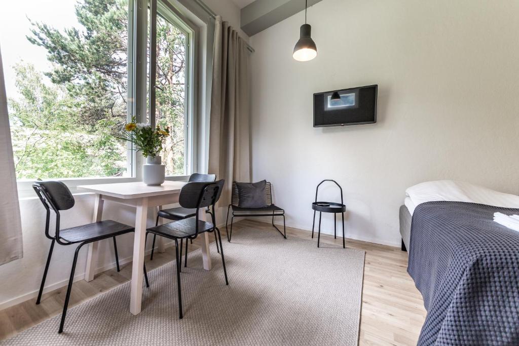 ein Schlafzimmer mit einem Tisch, Stühlen und einem Bett in der Unterkunft Spot Apartments Hiekkaharju in Vantaa