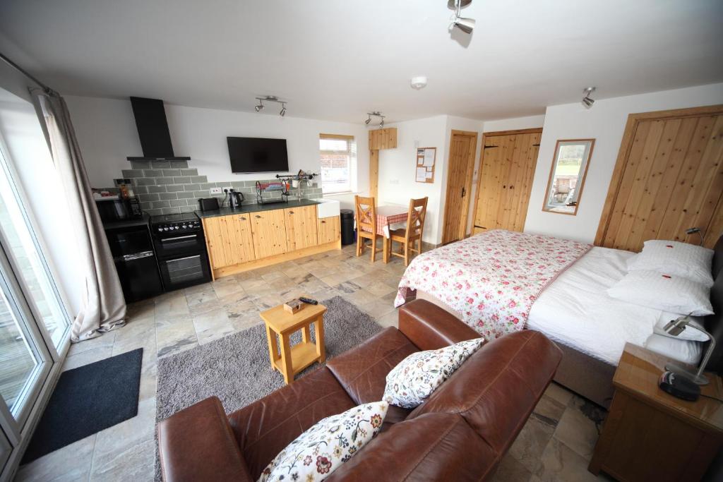 a bedroom with a bed and a couch at Lynton Lodge Studios in Keswick