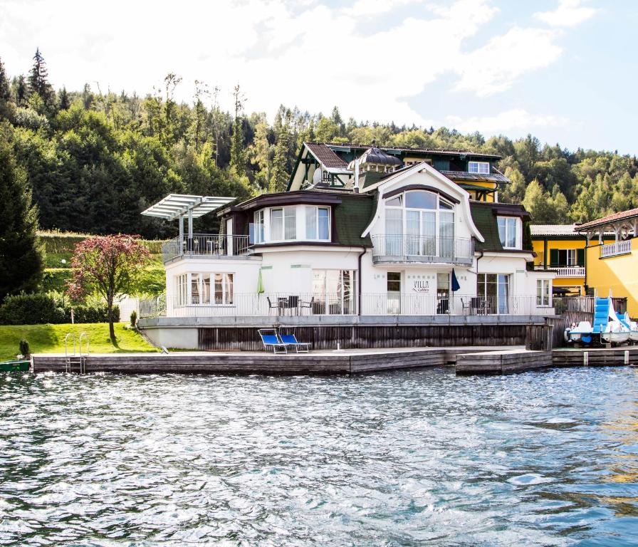 a large house on a dock on the water at Villa Cattina in Seeboden