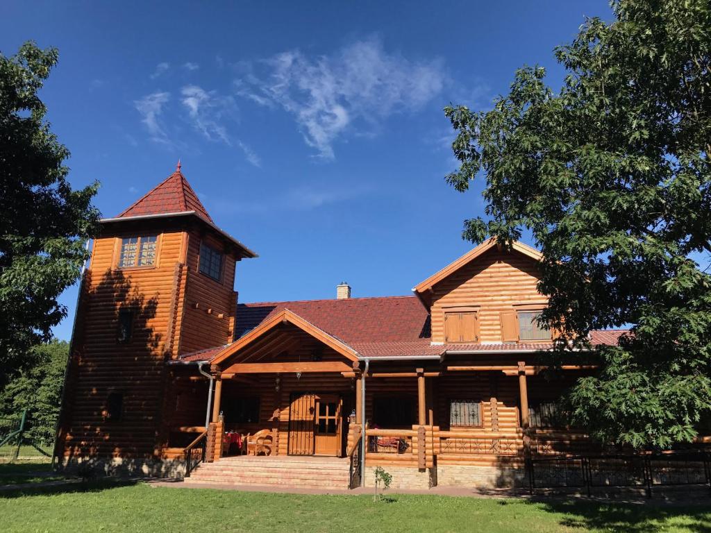 a log cabin with a tower on top of it at Villa Kazaw in Kaszó