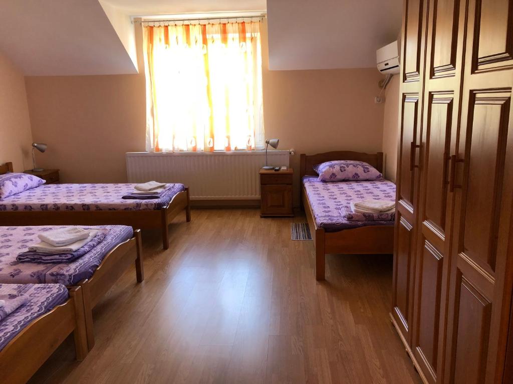 a small room with two beds and a window at Vila de lux in Bela Crkva