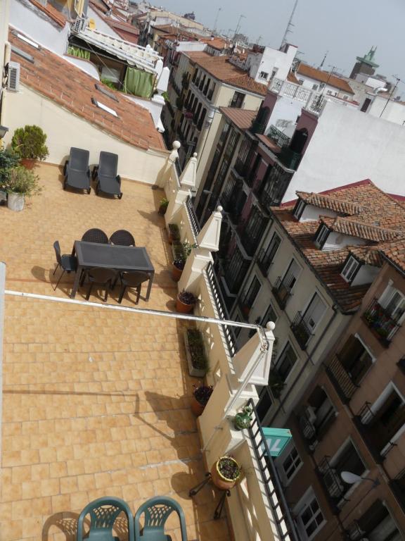 a balcony with a table and chairs and buildings at Hostal America in Madrid
