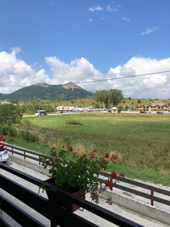 a view of a field and a fence with flowers at Via Osvaldo Moretti(complessoShalimar) in Ovindoli