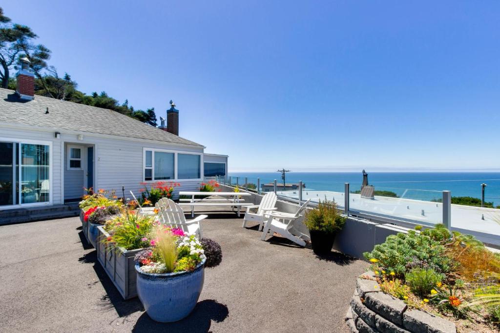 a house with a bunch of potted plants and the ocean at Wycliff Beach Condo in Lincoln City