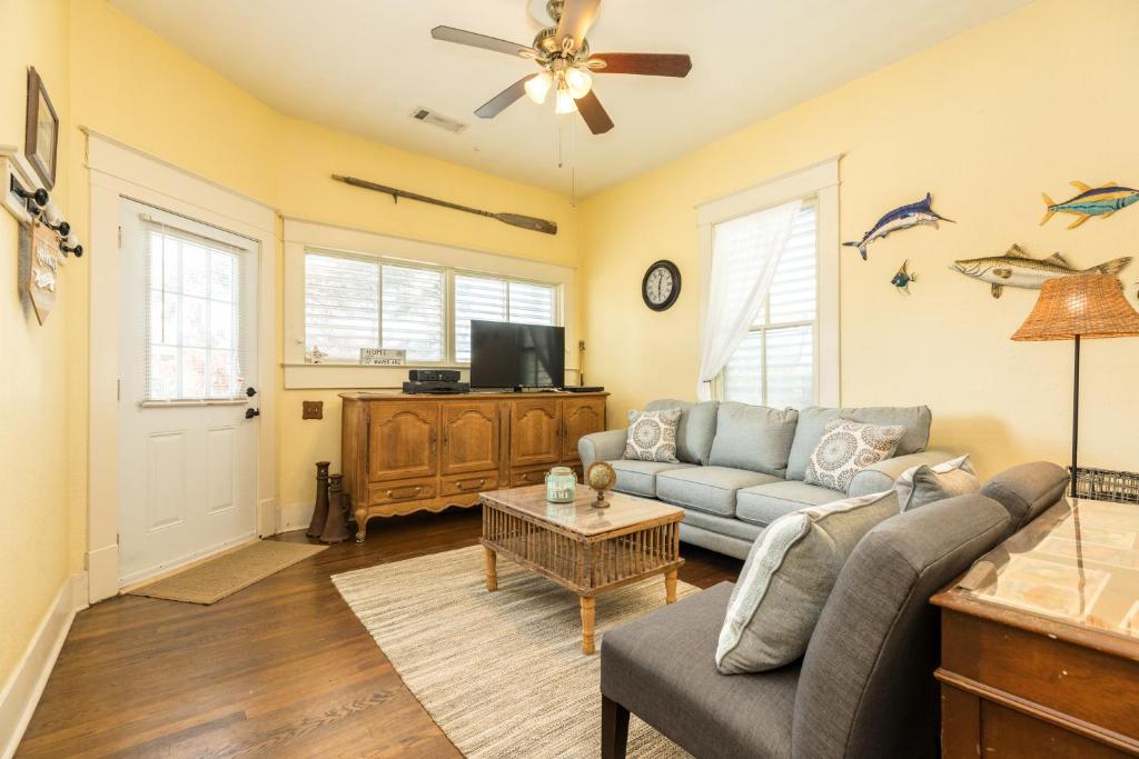 a living room with a couch and a tv at Castaway Cottage in Galveston