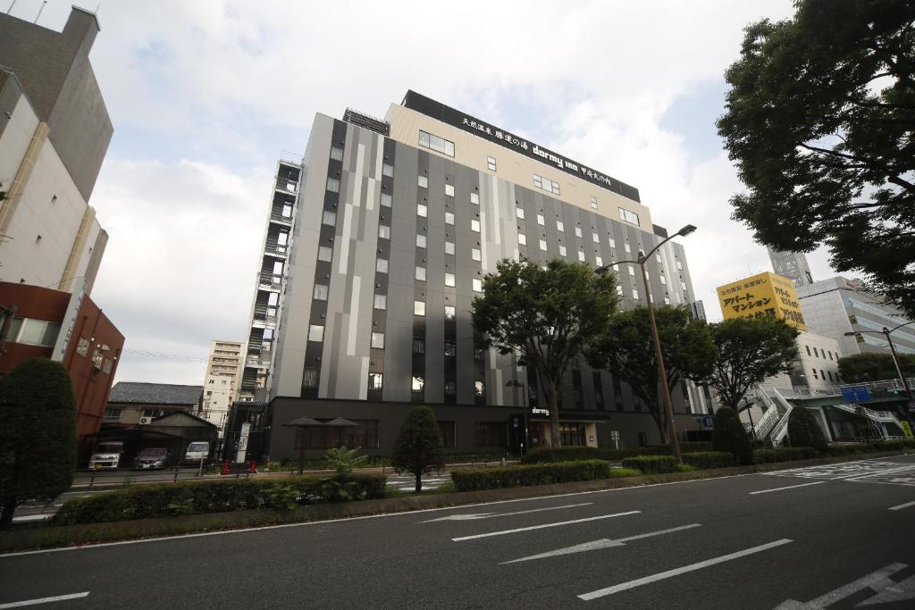 un grand bâtiment sur le côté d'une rue dans l'établissement Dormy Inn Kofu Marunouchi, à Kōfu