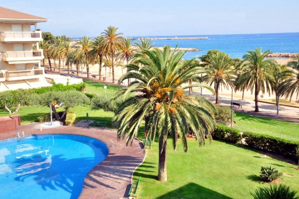 un resort con piscina, palme e spiaggia di Magica Planet Costa Dorada a Cambrils