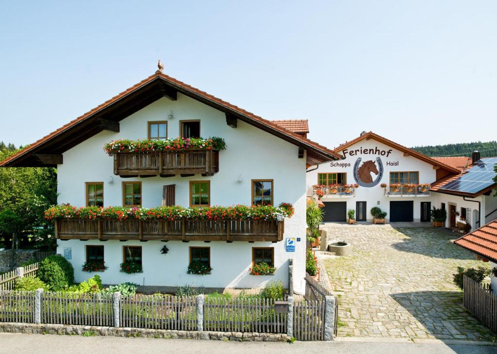 een wit huis met bloembakken op de ramen bij Ferienhof "Schoppa-Haisl" in Sonnen