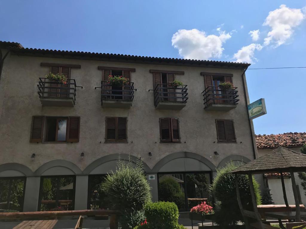 un bâtiment avec des plantes en pot sur les fenêtres dans l'établissement Hotel Panoramico, à Corfino