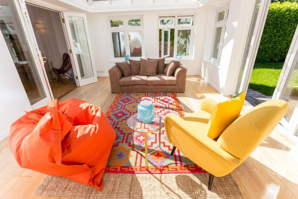 een woonkamer met 2 stoelen en een bank bij The Queen Edith Place - Lovely 6BDR Home in Secluded Area in Cambridge
