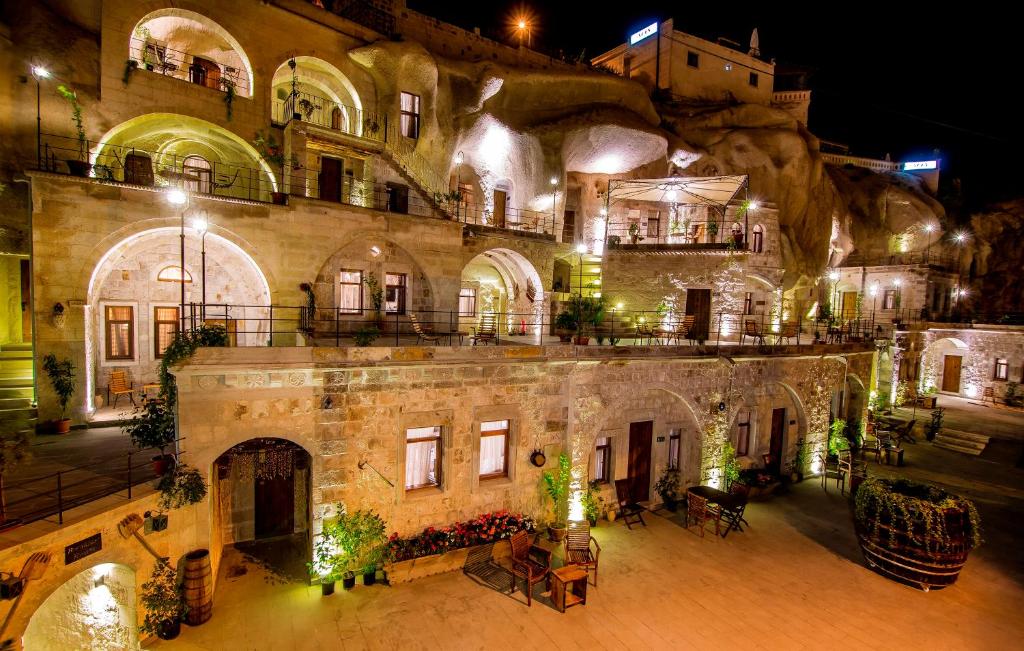 een oud stenen gebouw met 's nachts een binnenplaats bij Hera Cave Suites in Goreme