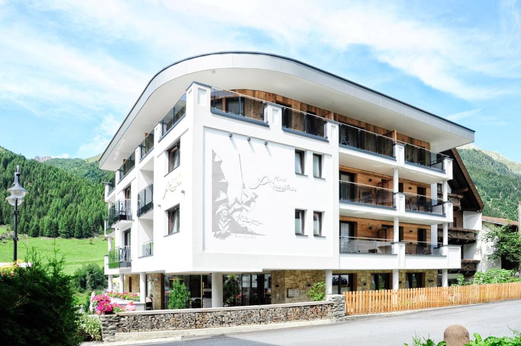 a large white building with a large window at Hotel Arnika in Ischgl