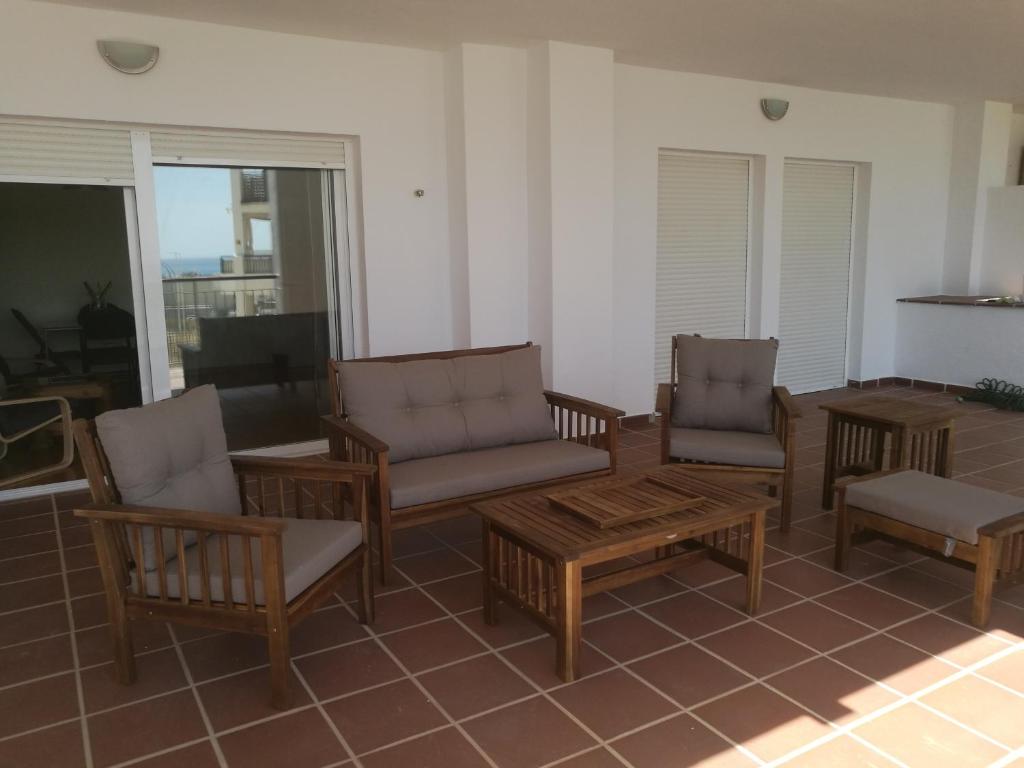 トレ・デ・ベナガルボンにあるApartamento cercano a la playa con gran terrazaのリビングルーム(椅子、テーブル、ソファ付)