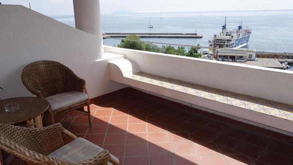 a balcony with a view of the ocean and a boat at Hotel Bellavista in Santa Marina Salina