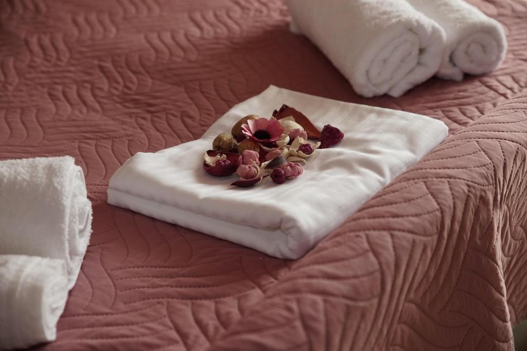 toalla blanca con flores encima de la cama en Nikitas Apartment, en Kanali