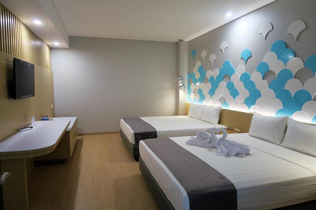 a hotel room with two beds and a sink at Nomaden Urban Stay in Semarang