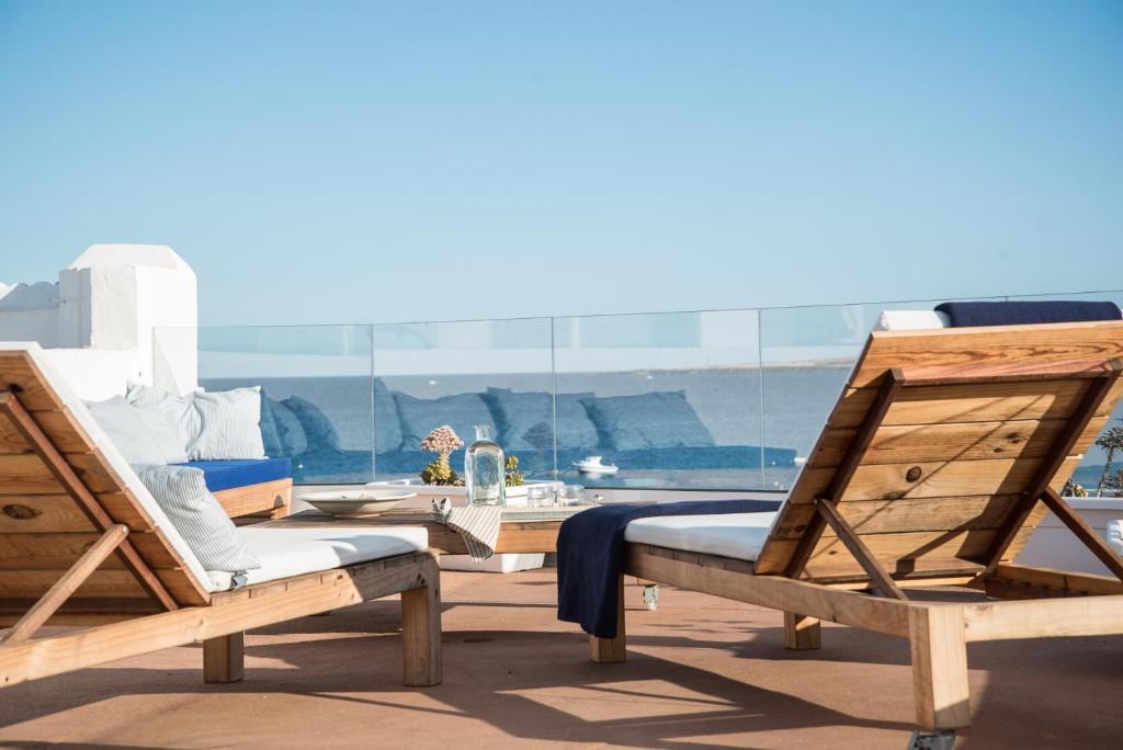 2 Holzstühle auf einer Terrasse mit Meerblick in der Unterkunft Modern home with Ocean View in Arrieta
